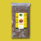 A bag of dog food branded 'Turkey Dinner' from As Nature Intended, surrounded by images of raw turkey meat, vegetables, and fruit on a wooden table against a yellow background with green leaves.