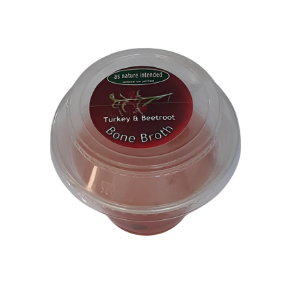 Packaging of 'As Nature Intended' Bone Broth for dogs and cats, contained in a clear plastic jar with a red and white label.
